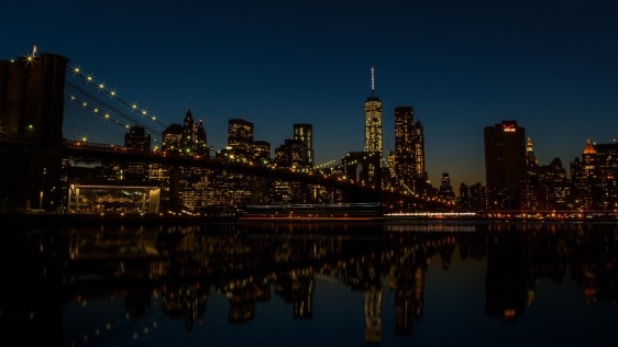 A nighttime city skyline view in the background.