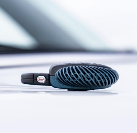 Closeup view of the signature MINI Cooper S Convertible Seaside Edition key sitting on the hood of a MINI Cooper S Convertible Seaside Special Edition in Nanuq White.