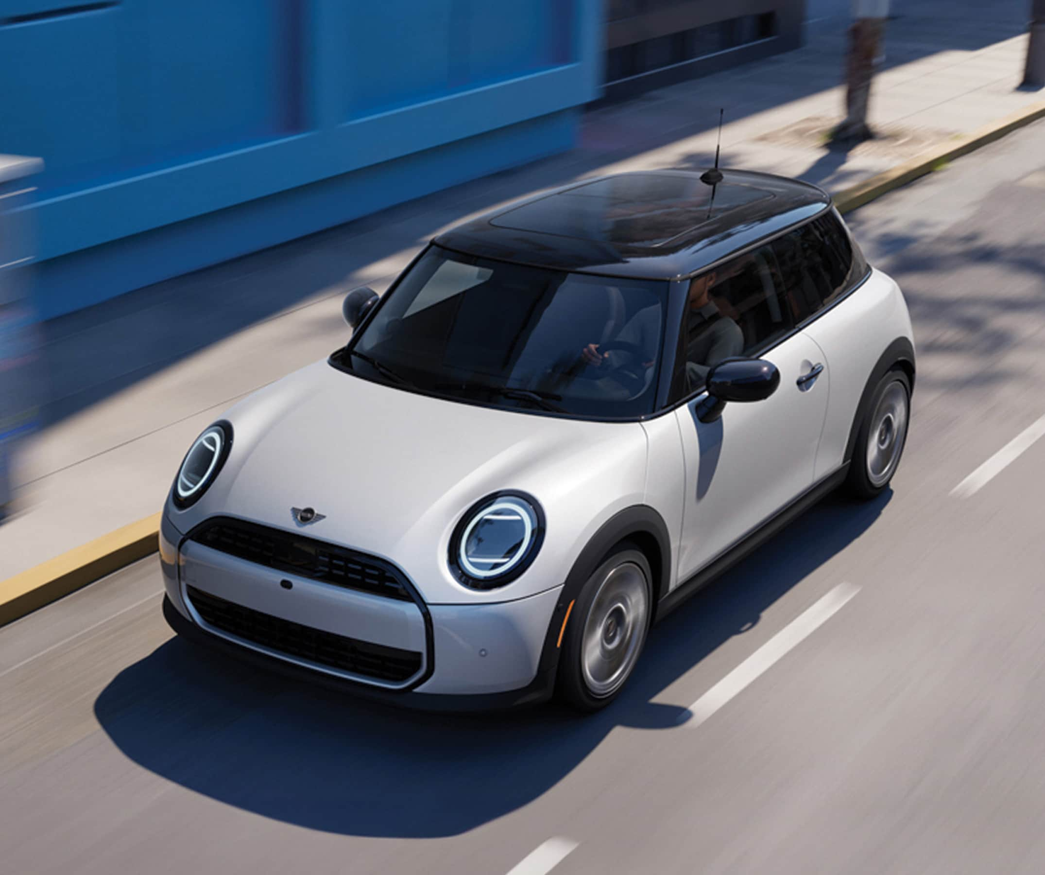 Bird's-eye view of a MINI Cooper 2 Door driving down a street.