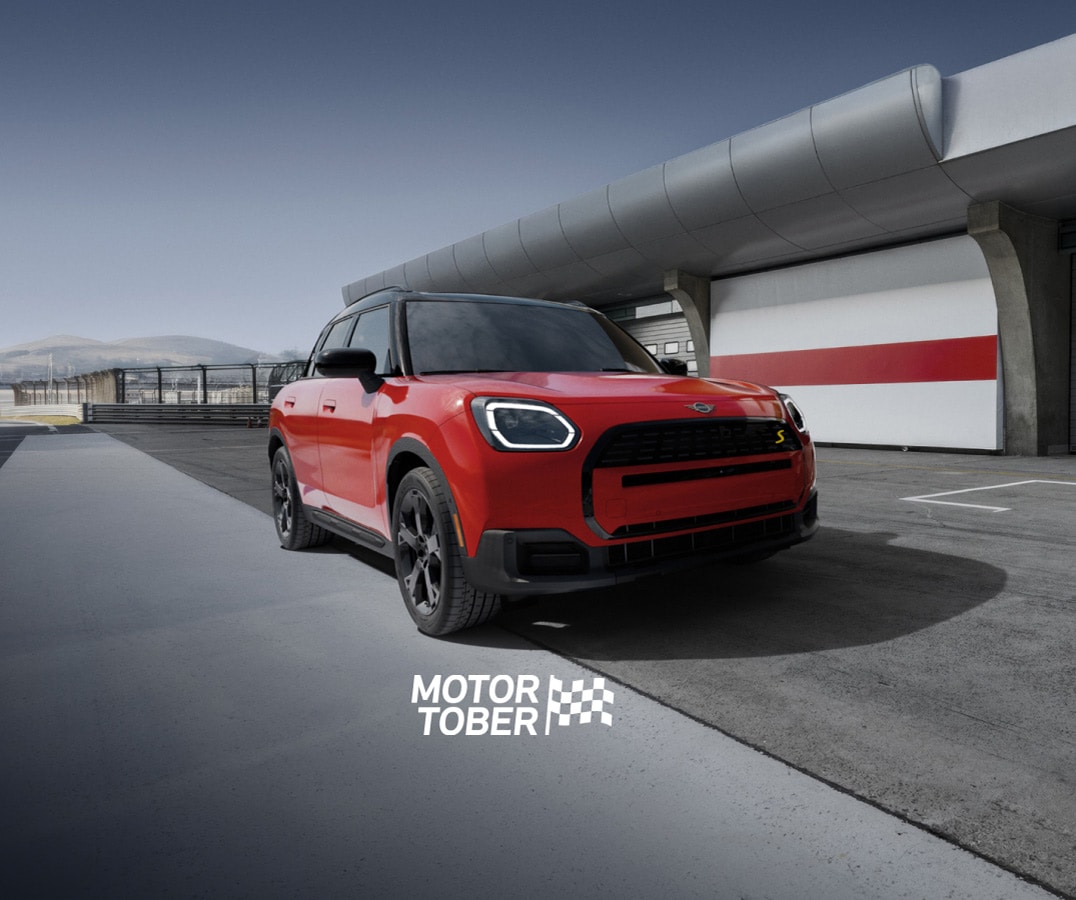 The MINI Countryman SE ALL4 parked on an empty racetrack with a dramatic vignette.