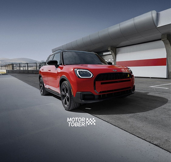 The MINI Countryman SE ALL4 parked on an empty racetrack with a dramatic vignette.