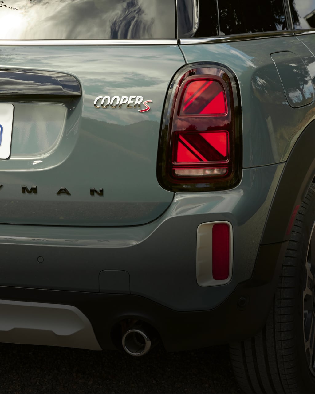 Closeup back view of a dark green MINI Countryman, including the bumper and Union Jack taillights.