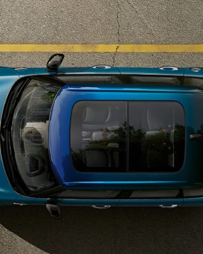 Overhead view of a blue MINI Hardtop 4 Door with a Soul Blue multitone roof parked on a street surface.